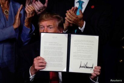 FILE - U.S. President Donald Trump holds an executive order relieving qualified disabled veterans of federally held student loan debt at the AMVETS (American Veterans) National Convention in Louisville, Kentucky, Aug. 21, 2019.