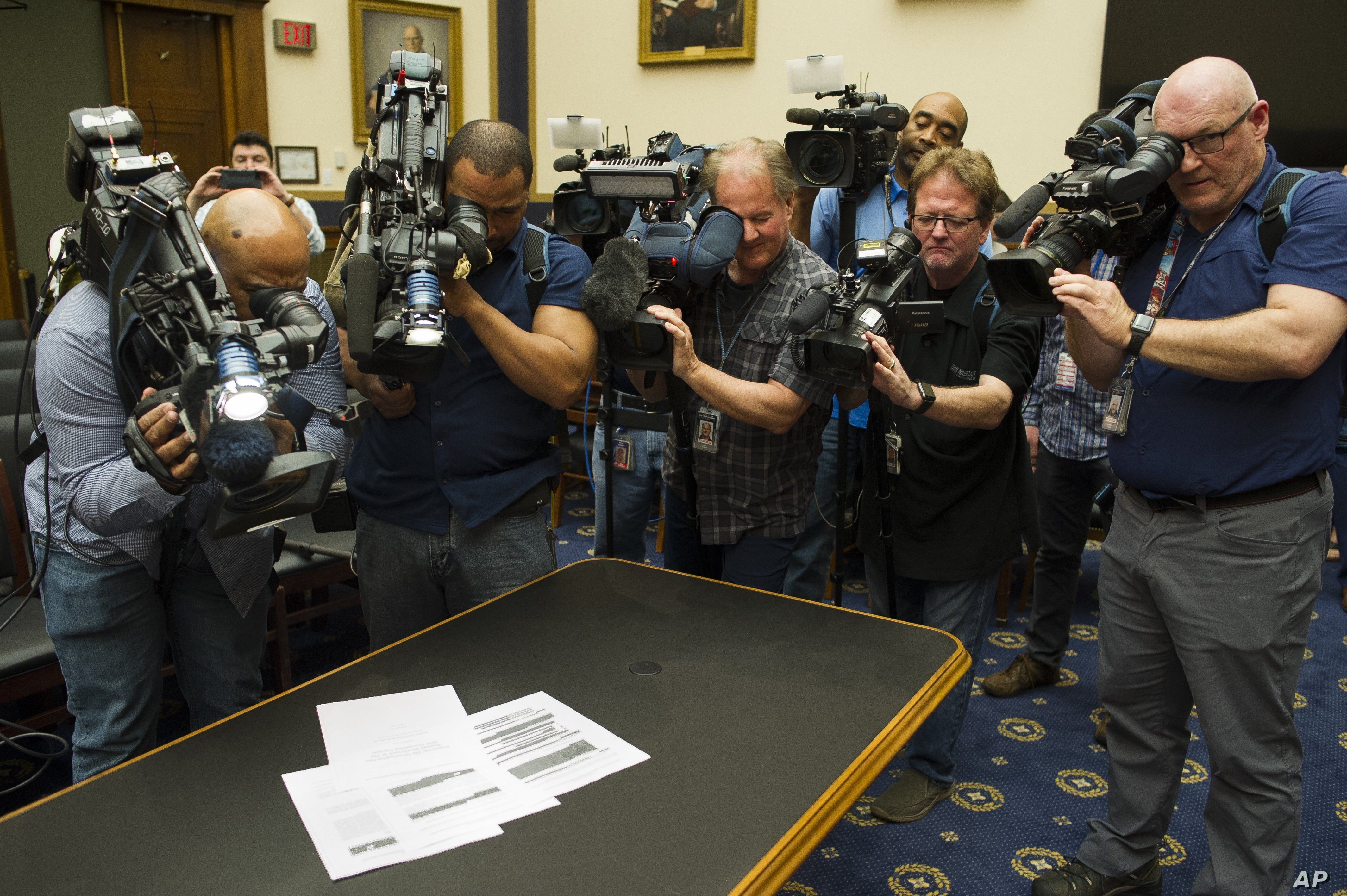 Photojournalists photograph four pages of the Mueller Report laid on the witness table in the House Intelligence Committee hearing room on Capitol Hill, April 18, 2019.