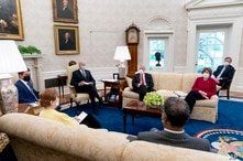 President Joe Biden meets with Transportation Secretary Pete Buttigieg, left, and members of congress to discuss his jobs plan in the Oval Office of the White House in Washington, April 19, 2021.