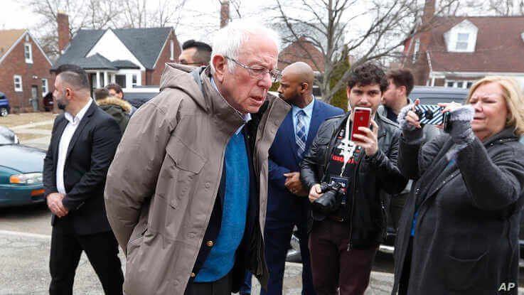 Democratic presidential candidate Sen. Bernie Sanders, I-Vt., visits outside a polling location at Bow Elementary in Detroit.